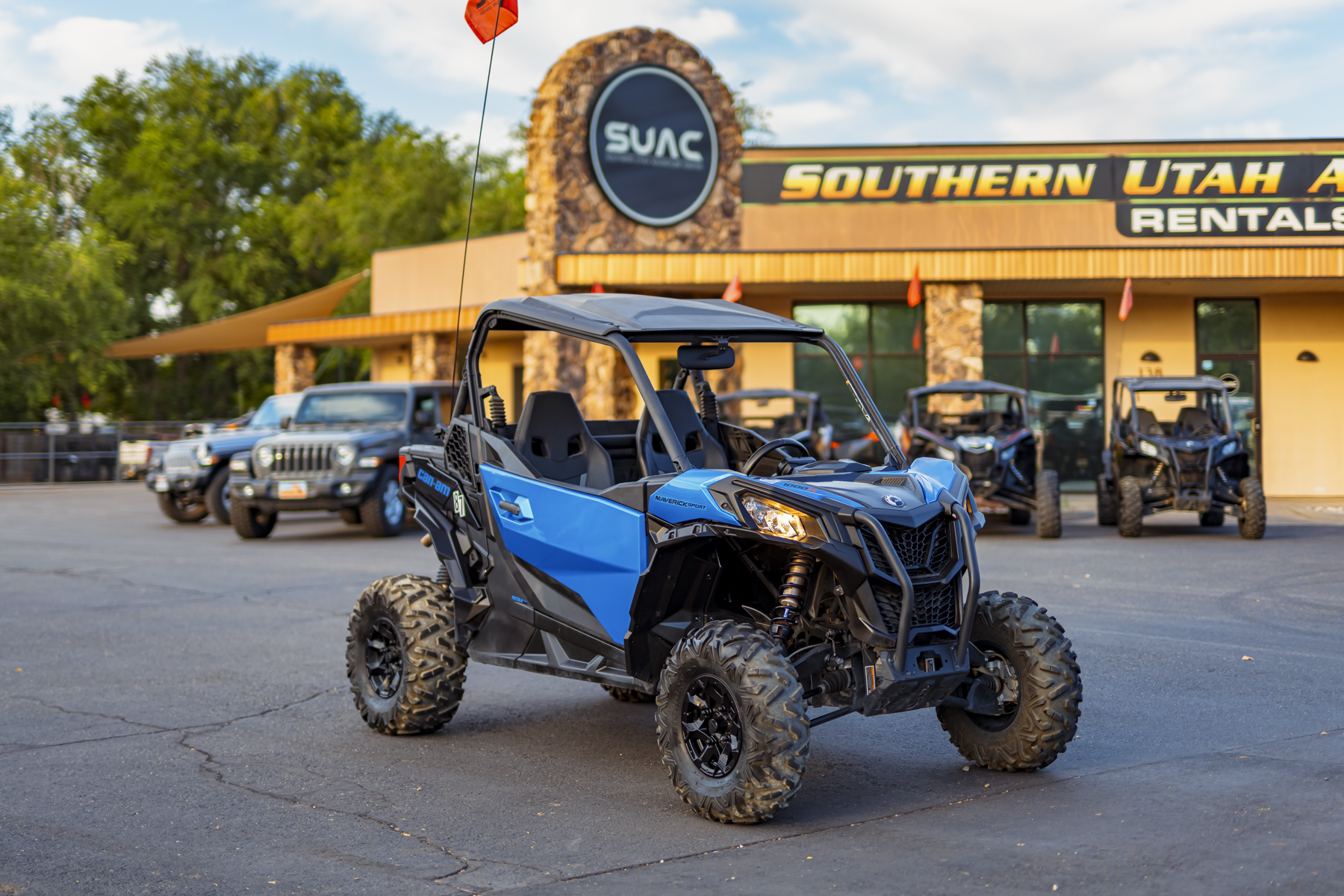 Blue Can-Am Maverick Sport UTV parked at Southern Utah Adventure Center in Hurricane, Utah, ready for off-road adventures on sand dunes and scenic trails near Zion National Park